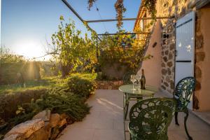 a patio with a table and chairs and an arbor at Cottage les Marjoris Tanneron in Tanneron