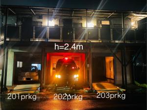 a truck is coming out of a building at night at Shirakkan - Vacation STAY 16295 in Hamura
