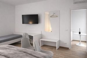 a white living room with a table and chairs at Cìvitas Suite ApartHotel in Catania
