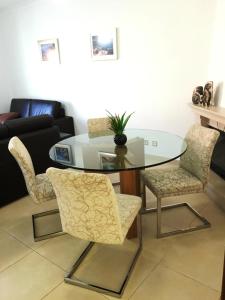 a glass table and chairs in a living room at São Martinho do Porto Beach Apartment in São Martinho do Porto
