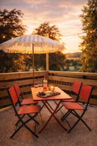 einen Tisch mit 2 Stühlen und einem Sonnenschirm in der Unterkunft Vinyle club-rétro 70's-6 pers-Terrasse-Wifi-Parking in Bellême