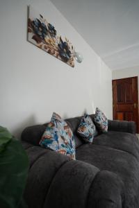 een bank met kussens erop in een woonkamer bij Modern Kisumu Apartment Near Airport, Malls & Lake Victoria in Kisumu