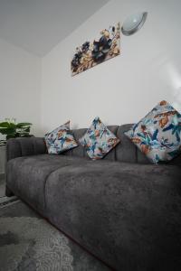 een bank met kussens erop in een woonkamer bij Modern Kisumu Apartment Near Airport, Malls & Lake Victoria in Kisumu