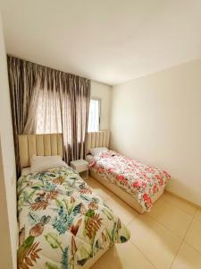 a bedroom with two beds and a window at Cozy apartment adana in Aourir +13 photos