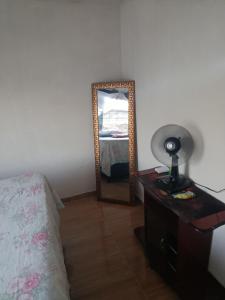 a bedroom with a bed and a mirror on a dresser at Quarto 11 casa in Campina Grande