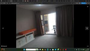 een kamer met een raam en een bank in een kamer bij KINGSLEY Green in Gqeberha