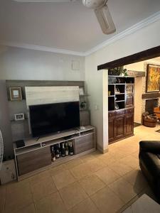 un soggiorno con una grande TV a schermo piatto di Las Cortaderas House a Trancas