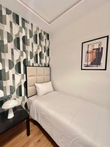 a bedroom with a white bed and a table and a bed sidx sidx at Spacious apartment in Tétouan