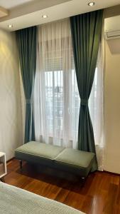 Bett vor einem Fenster mit Vorhängen in der Unterkunft Gorica Hill Luxury Residence in Podgorica