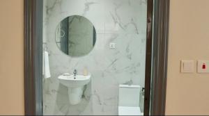 ein Badezimmer mit Waschbecken, Spiegel und Toilette in der Unterkunft Ghanas Finest The Reach in East Legon + 3 Fotos