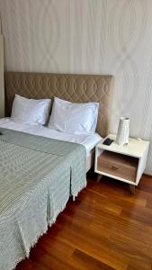 ein Schlafzimmer mit einem Bett und einem Nachttisch mit Telefon in der Unterkunft Gorica Hill Luxury Residence in Podgorica + 12 Fotos