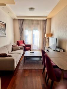 ein Wohnzimmer mit Sofa und Tisch in der Unterkunft Gorica Hill Luxury Residence in Podgorica