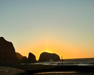 een zonsondergang op een strand met rotsen in de oceaan bij Acogedor departamento en Constitución in Constitución