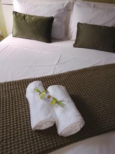 a bed with white socks and a bottle on it at Villa DAV'ANGEL in Le Lamentin