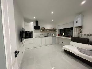 een witte keuken met een bed in een kamer bij Letterkenny Town Centre Apartment in Letterkenny