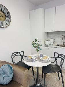 a white kitchen with a table with food on it at Pastello & Bianco in Biskupiec +16 photos