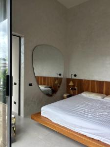 una camera da letto con un grande letto e uno specchio rotondo di Tropical villa a Ko Phangan