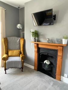 a living room with a chair and a fireplace at Millpool House in Dartmouth +17 photos