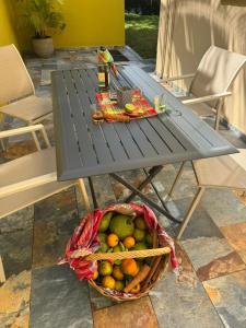 a basket of fruit sitting next to a picnic table at Villa DAV'ANGEL in Le Lamentin
