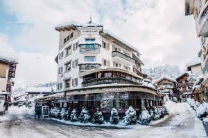 un grande edificio con alberi di Natale davanti di Melba Megeve emplacement de rêve dans le village au calme a Megève
