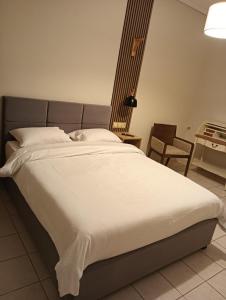 un grande letto bianco in una stanza con una sedia di Urban Mountain House a Karpenision