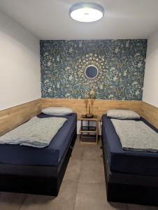 een slaapkamer met twee bedden en een spiegel aan de muur bij Meet & Greet am Radfernweg E-Bike modern in Erfurt