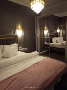 una camera da letto con due letti e un lampadario di Exquisite Prima a Oradea