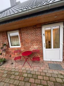 a group of red chairs sitting outside of a brick house at Schildetal Apartment 1 in Camin