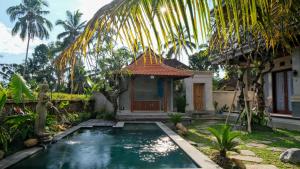 a house with a swimming pool in front of a house at The Uma Tapan in Penginyahan