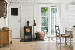 een woonkamer met een houtkachel. bij Classic 1937 Cottage On A Natural Plot in Nykøbing Sjælland