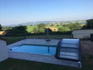a swimming pool in the yard of a house at Gîte Sous Nous in Youx