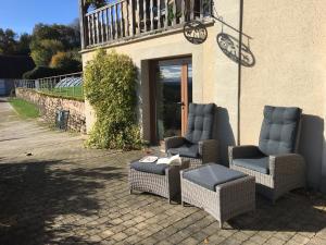een groep stoelen buiten een gebouw bij Gîte Sous Nous in Youx