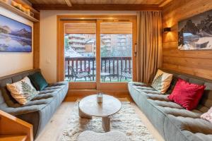 ein Wohnzimmer mit Sofas und einem Tisch in der Unterkunft Troillet 11 in Méribel