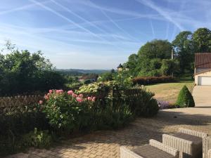 een uitzicht vanuit de tuin van een huis met bloemen bij Gîte Sous Nous in Youx