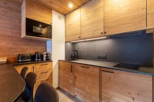 eine Küche mit Holzschränken und einem Tisch und Stühlen in der Unterkunft Troillet 11 in Méribel