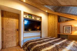 ein Schlafzimmer mit Bett und Flachbildfernseher in der Unterkunft Troillet 11 in Méribel