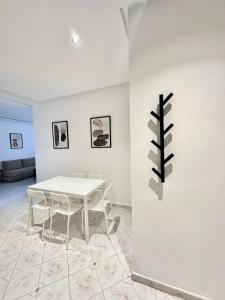 a white dining room with a white table and chairs at Spacious apartment in Tétouan