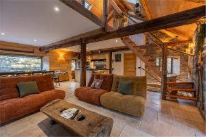 a living room with two couches and a table at Chalet - Les Fermes de Céline - Barcelonnette in Enchastrayes