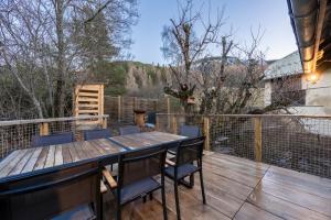 a patio with a wooden table and chairs on a deck at Chalet - Les Fermes de Céline - Barcelonnette in Enchastrayes