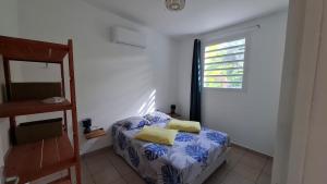 een kleine slaapkamer met een bed en een raam bij Le Havre du Voyageur - Colibri in Le Moule +24 foto's