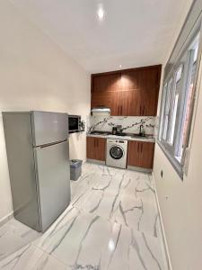 a kitchen with marble floors and a refrigerator at Spacious apartment in Tétouan +14 photos