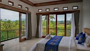 a bedroom with a bed and large windows at The Uma Tapan in Penginyahan +35 photos
