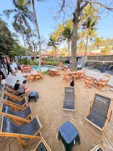 a group of chairs and tables and a pool at Raizes do Mar Hotel - Pé Na Areia - Opções de Suites com Ofuro Aquecido, SPA Privativo, Vista ao Mar ou Montanha, com Estacionamento e Café Incluso in Guarujá +23 photos