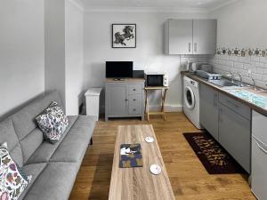 een woonkamer met een bank en een tafel in een keuken bij The Nest - Uk46879 in Woodbury