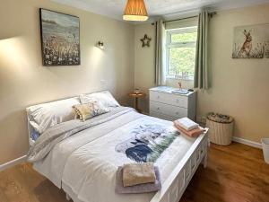 een slaapkamer met een bed en een raam bij The Nest - Uk46879 in Woodbury