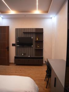 ein Hotelzimmer mit Bett und Flachbildfernseher in der Unterkunft HomeGround Sector 89 -3 BHK Villa in Gurgaon + 9 Fotos