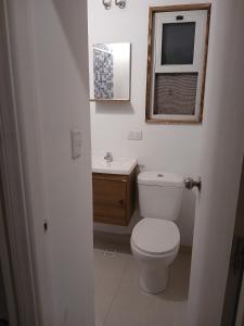 een badkamer met toilet, wastafel en raam bij Mar y Cerros in Piriápolis +21 foto's