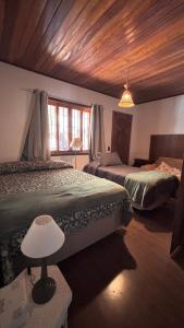 En eller flere senge i et værelse på Encanto das Araucárias