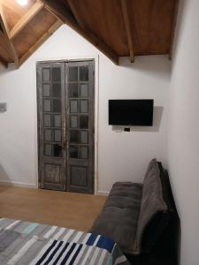 een slaapkamer met een bank en een tv aan de muur bij Mar y Cerros in Piriápolis