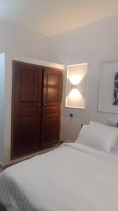 una camera da letto con un letto, una luce e un armadio di Appartement Ode de paix a Cotonou Cadjehoun